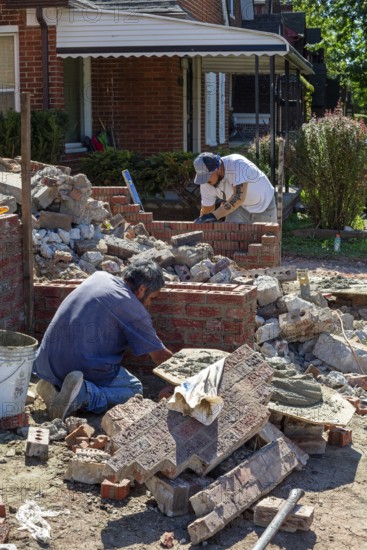 Detroit, Michigan - Workers rebuild the front porch of a house they are remodeling in the
