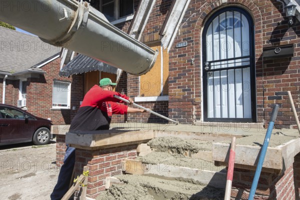 Detroit, Michigan, Workers rebuild the front porch of a house they are remodeling in the