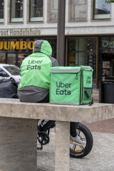 Bicycle transport in Groningen, Uber Eats, courier driver waiting for new orders, with e-bike in