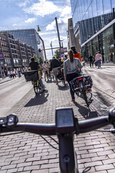 Ride your bike on the central cycle path on Lange Viestraat, Vredenburg, in the city centre of