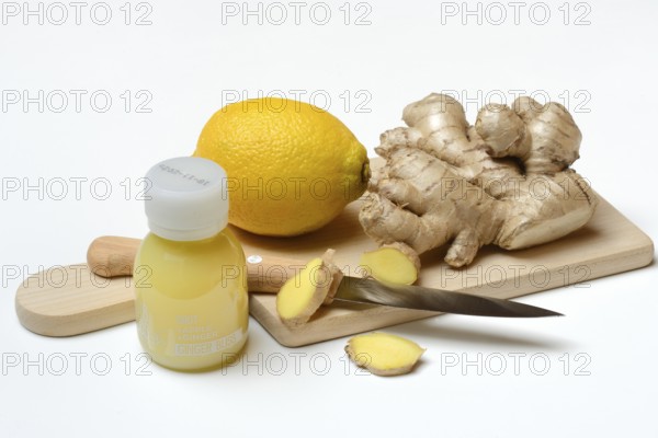 Ginger root and lemon on cutting board and ginger shot