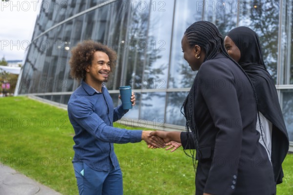Diverse business professionals meeting and exchanging a friendly handshake outdoors in a modern
