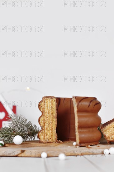 Cut open cake called 'Baumkuchen', a German layered cake glazed with chocolate, surrounded by