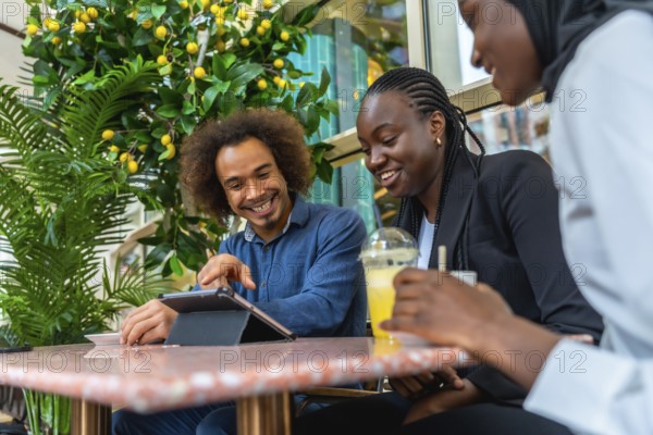 Diverse group of young adult friends enjoying a social gathering in a modern cafe, laughing and