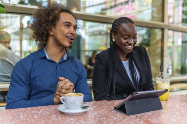 Two diverse business professionals are meeting in a relaxed cafe environment, discussing ideas and