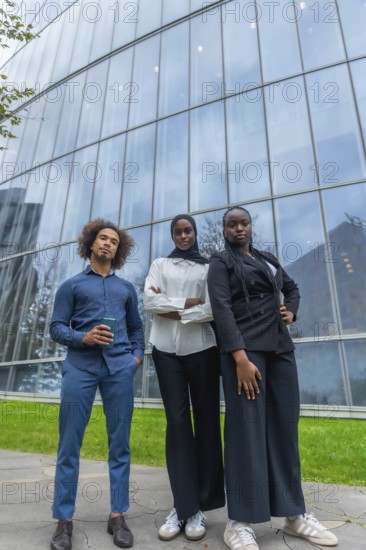 Young diverse business team standing together with confidence outdoors, reflecting professionalism,