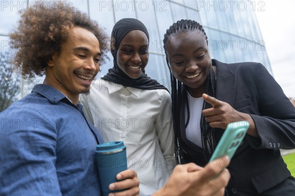 Group of diverse friends standing close together, smiling and laughing while looking at a