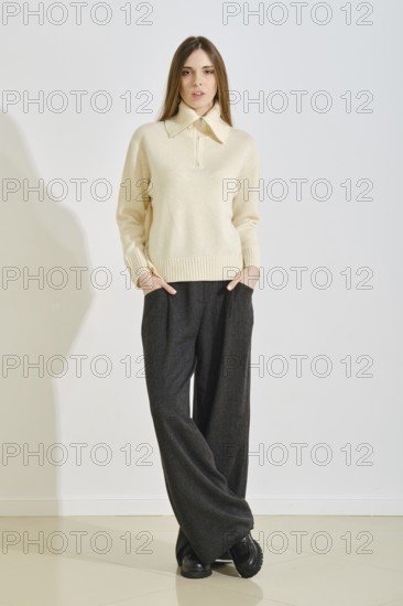 A young woman stands confidently in a stylish, cozy winter outfit that emphasizes convenience and
