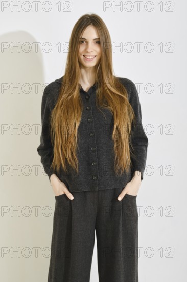 Smiling woman poses in a comfortable black outfit featuring a soft button-up top and loose pants on