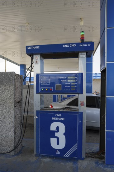 CNG station with blue gas pump, methane display and vehicle in background, gas filling station,