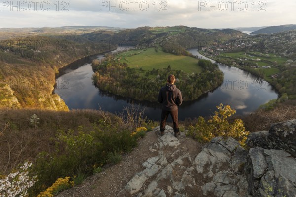 Man standing on a rock at sunset on spring evening at the loop of the Vltava (Vltava) View Solenice