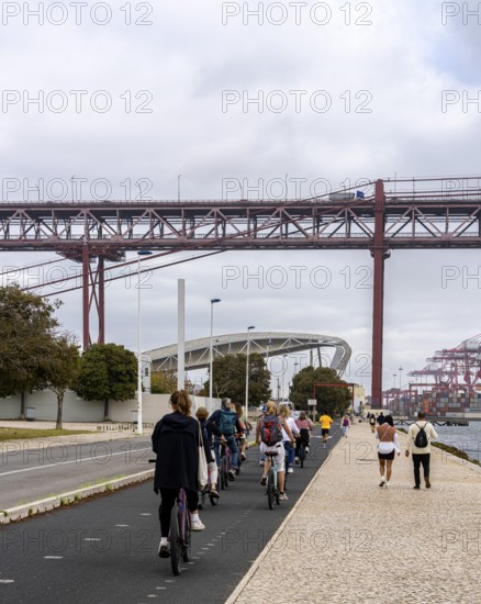 Cyclists on Ponte 25 de Abril, 3.2 km long bridge in Portugal with a 2278 meter long suspension