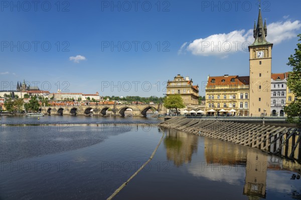 Vltava embankment with Old Town Water Tower, Novotný Bridge and Charles Bridge in Prague, Czech