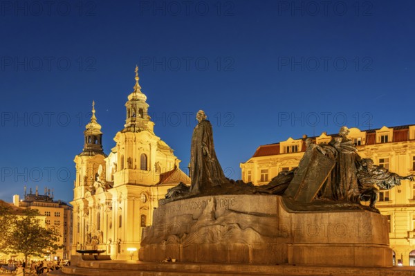 The Baroque St. Nicholas Church and the Jan Hus Memorial on Old Town Square at dusk, Prague, Czech