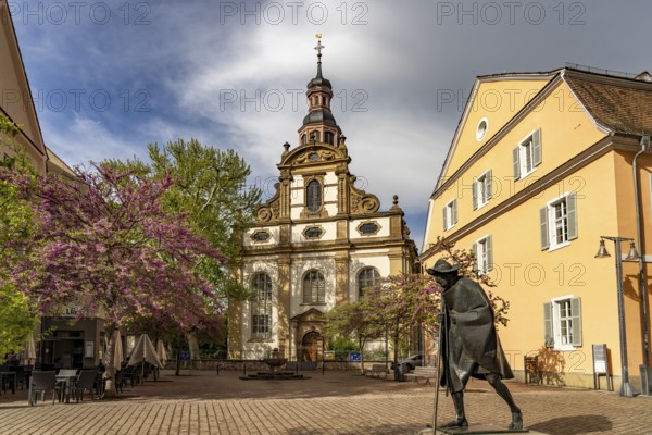 Sculpture of a Saint James Pilgrim on Maximilianstraße and the Trinity Church in Speyer,
