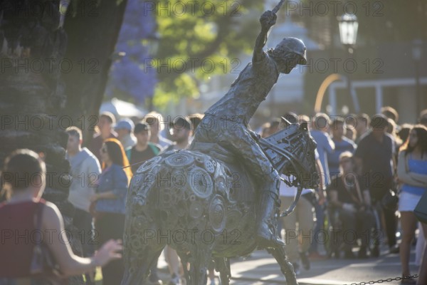Metal sculpture of a polo player on the grounds of the polo stadium with many visitors, Buenos