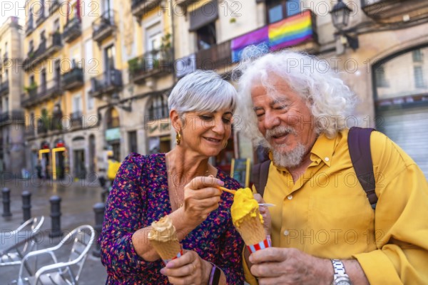 Happy senior couple sharing ice cream while sightseeing in a european city, smiling together with a