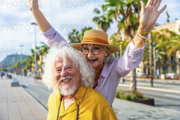 Senior couple enjoying their summer vacation together in a vibrant city, smiling brightly and