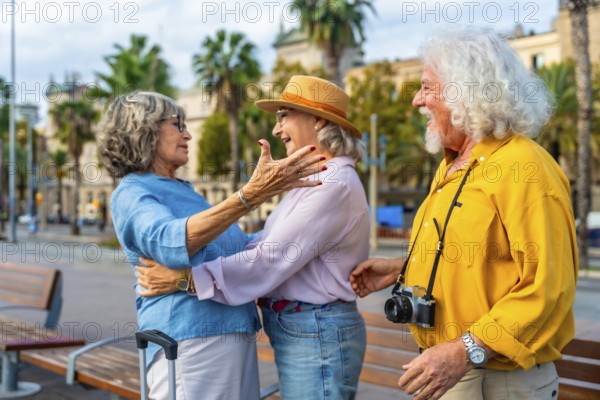 Senior friends embrace in an urban square, joyful reunion while traveling overseas, smiling and