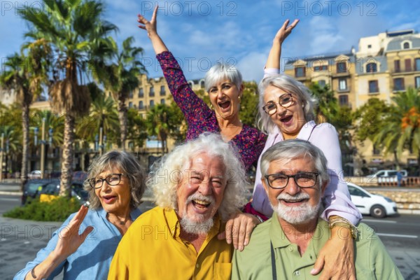 Happy senior friends smiling and raising hands, celebrating friendship and active retirement during