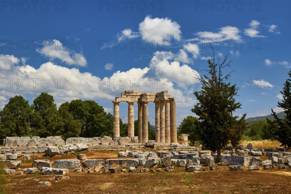 Stone ruins and ancient pillars against a cloudy blue sky, Nemea, Ancient Zeus Church,