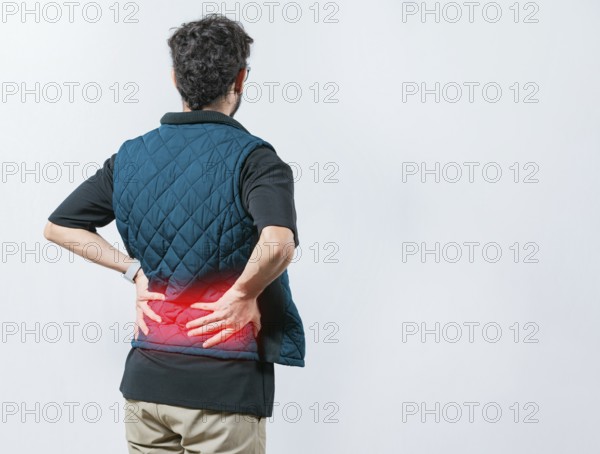 Lumbar problems. Suffering male with pain holding his back isolated. Person with spine problems.