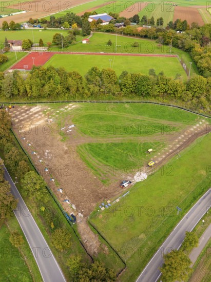 Aerial view of a green landscape with tennis court and surrounding trees, PV Freifaechenanlage