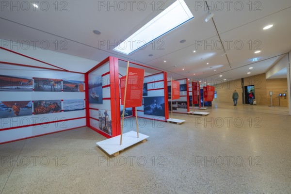 Modern exhibition room with red information stands and bright lighting in a minimalistic design,