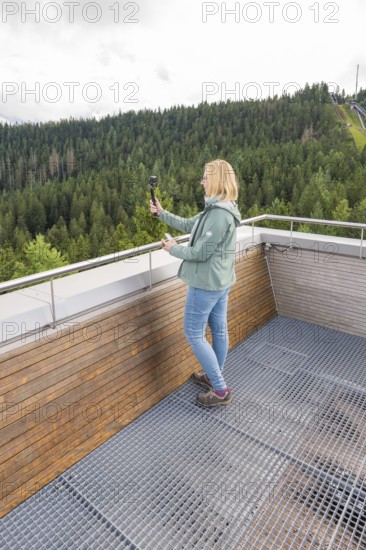 Person with selfie stick enjoying views of wooded hills from a vantage point, Ruhestein National