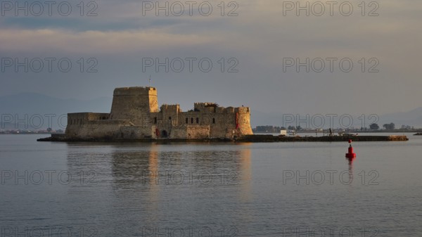Bourtzi island fortress, old fort on a small island in calm sea with a red buoy in the foreground,