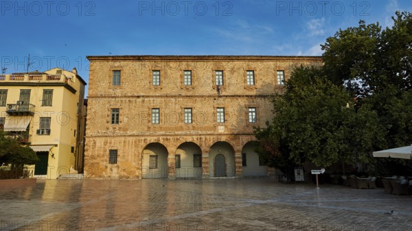 Old town of Nauplion, historic brick building with round arches in front of a paved square with