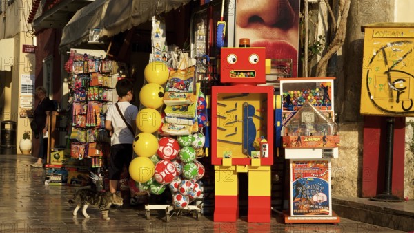 Old town of Nauplion, A colorful toy store with a retro robot and balloons in a sunny street,
