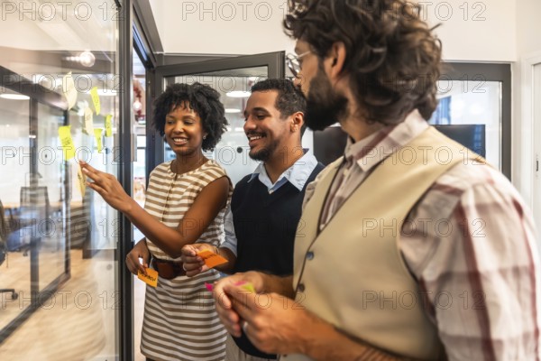 Diverse business team collaborating in a modern office, sharing ideas and planning strategy by