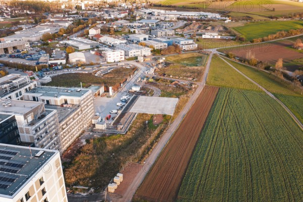 Outskirts of town with fields and construction areas, roads lead through rural surroundings, new