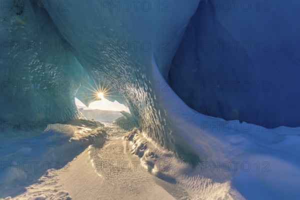 Midnight sun shining in glacial ice cave at Mohnbukta, bay at western shore of Storfjorden in