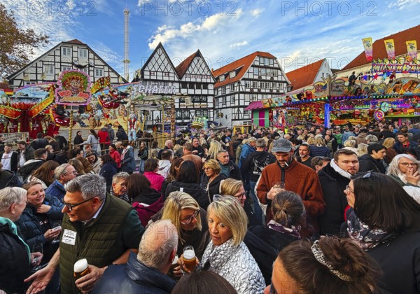 Many people at the All Saints Fair in front of half-timbered houses, largest old town fair in