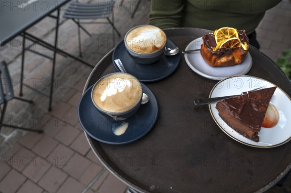 Cappuccino and cake served on a tray in a street café, Hanseatic City of Lübeck,