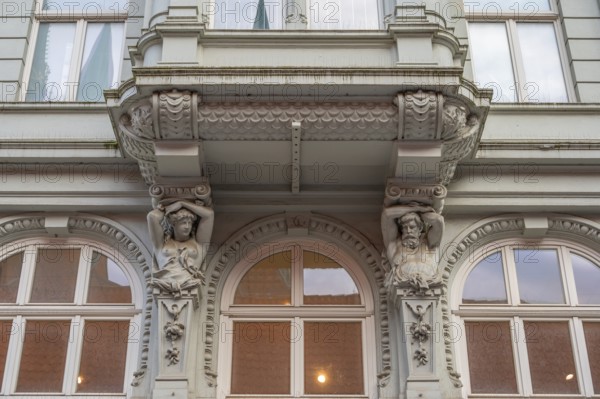 Caryatids at the bottom of a bay window in a historic residential building, 19th century, Hanseatic