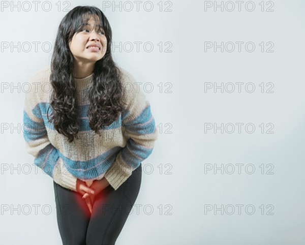 Medical problem urinary incontinence. Asian young woman with urinary problems, Female with hands on