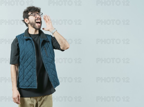 Young man in glasses shouting a promotion isolated. Handsome guy shouting an announcement