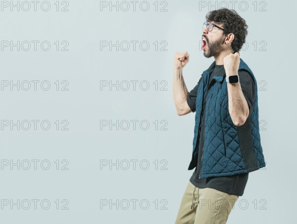 Happy guy with sunglass celebrating something. Excited young man celebrating looking at camera