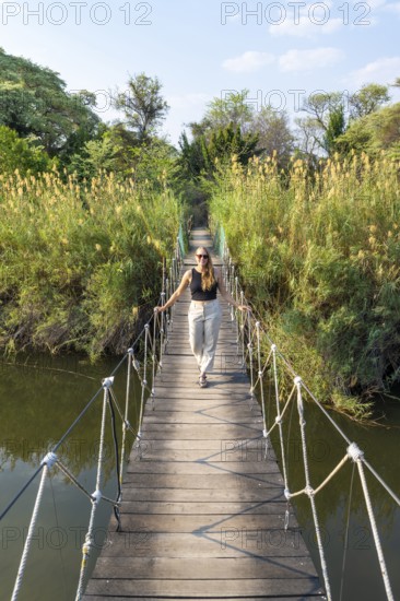 Toruist on the Kavango River, suspension bridge at Camp Kwando, Zambezi region, Caprivi Strip,