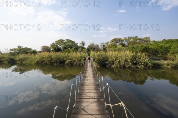 Toruist on the Kavango River, suspension bridge at Camp Kwando, Zambezi region, Caprivi Strip,