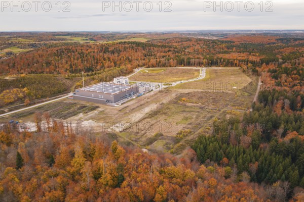 Industrial plant surrounded by autumnal forest with fields and roads in the background, new