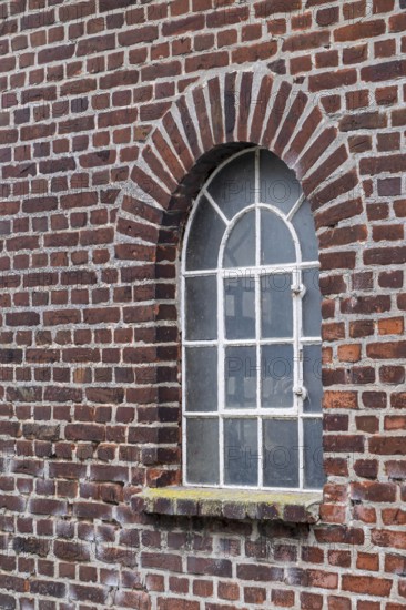 Old brick wall with an arched window and a rustic architectural style, Düstermühle, Münsterland,