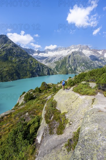 Female mountaineer in front of picturesque mountain landscape, turquoise-blue mountain lake