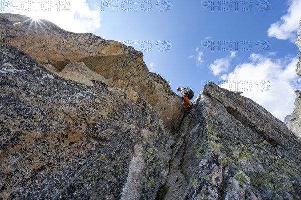 Mountaineers on steep rock face in the secured via ferrata Crocodile Mountain Lake at