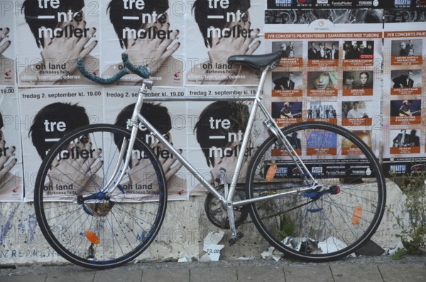 Racing bike set against a wall filled with posters in Odense, Fyn, Funen island, Denmark,