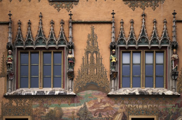 Painted façade with 4 medieval human sculptures, fresco cycle, window, town hall, old town, Ulm,