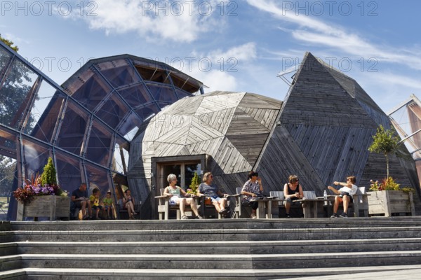 Modern roof structure made of wood and glass, modern architecture, visitors in front of Domen